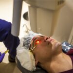 Corneal collagen cross-linking: an intraoperative view of a patient undergoing the procedure, with the riboflavin-soaked cornea fluorescing under ultraviolet light while a speculum holds the lids open