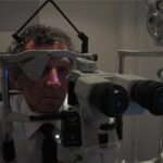 Goldmann applanation tonometry: a patient positioned at a Haag-Streit slit lamp with the Goldmann tonometer prism in place and the cobalt blue illumination activated for intraocular pressure measurement