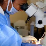 Intravitreal injection: an ophthalmologist performing a sterile intravitreal injection under the operating microscope, with the patient draped and a lid speculum in place